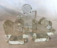 Front view of three clear glass angel candlesticks showing sizes