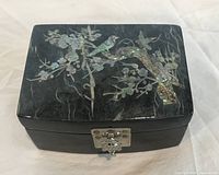 Top view showing mother-of-pearl inlay bird and floral design, metal clasp visible