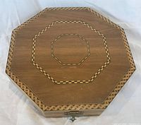 Closed octagonal box showing marquetry inlay and clasp