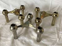 Five modular candlestick holders shown assembled; illustrates design and finishes