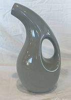 Front view of grey biomorphic ceramic jug showing circular handle and curved spout