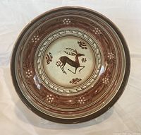Interior of hand-painted bowl showing deer motif and decorative bands