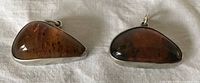 Front view of both silver and amber pendants
