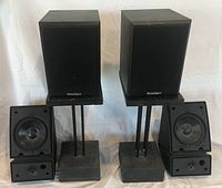 Front view of Paradigm speakers on stands with Polk speakers below