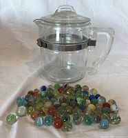 Percolator assembled with lid on, marbles in foreground