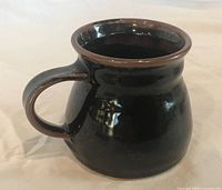 Full view of dark glazed stoneware mug with handle