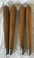 Four wooden tapered legs grouped together showing ferrules and hanger bolts