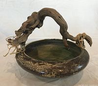 Overall view of signed Pat Webber stoneware bowl with driftwood handle and raffia ties