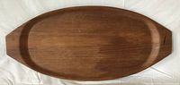 Top view of elongated oval teak tray showing grain and tapered ends