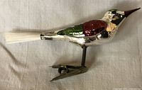 side view of mercury glass bird ornament showing painted colors, clip and tail