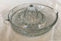 Top view of clear glass juicer showing reamer, handle and spout