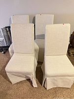 Front view of four cream striped parsons chairs