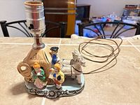 Full view of lamp showing horse, carriage, figures, socket, cord