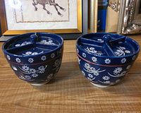 two ceramic bowls with matching three-section lids