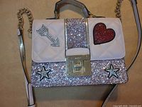 Front view showing glitter panel, embroidered patches, clasp