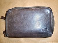 Front of brown leather wallet showing overall condition and zip-around edges