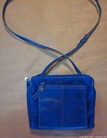 Front view showing blue leather Tignanello crossbody with front zip pocket and adjustable strap