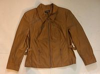 Front view of tan faux leather jacket showing zipper and pockets