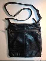 Front view showing leather texture, front zipper pocket, strap