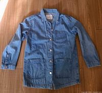 Full view of denim chore jacket front showing pockets and buttons