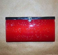 Front view red patent faux leather wallet with silver clasp