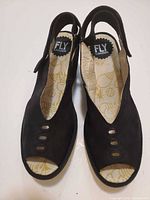 Top view of pair showing suede uppers, cut-outs, slingback straps, insole graphics