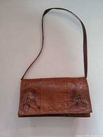 Full view of brown python leather purse with shoulder strap