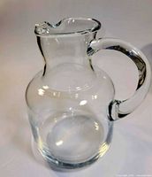 Full view of clear glass pitcher showing handle and body