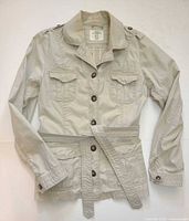 Front view of beige H&M safari jacket showing button front, belt, chest and lower pockets