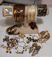Full group shot of watches, bangles, earrings, brooches and necklace on display stand