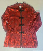 Front view of red satin jacket showing closures and pattern