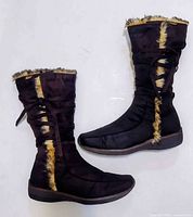 Full side view of both boots showing height, suede material, faux fur trim, and soles