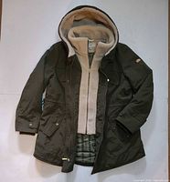 Front view of khaki parka showing hood, sherpa vest lining, pockets