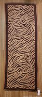 Full view of scarf laid flat showing entire animal stripe pattern and border