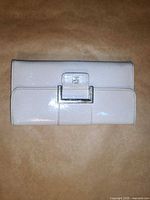 Front view closed showing white exterior and buckle clasp