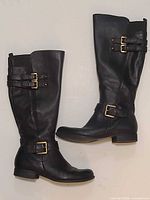 pair of black leather knee-high boots side view showing buckles