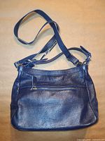 Front view of navy leather crossbody purse with strap extended
