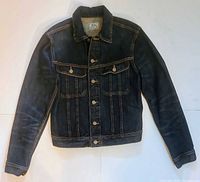 Front view of dark indigo denim jacket showing button closure and pockets