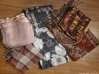 Overview of all six scarves laid on wooden floor