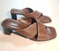 Side view of both mules showing leather uppers, straps, heels