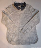 Front view of grey sweater with blue collar