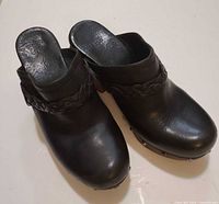 Top view of black leather clogs showing overall condition and open back