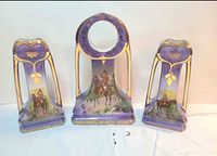 Full view of porcelain clock case with two matching vases