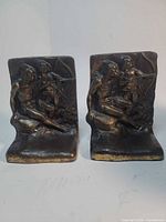 Front view of both cast bronze bookends showing relief scene