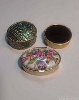 Three closed trinket boxes showing lid designs
