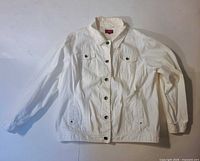 Front view of white denim jacket showing buttons and pockets