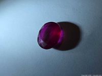 Oblique view of oval faceted ruby showing colour and pavilion
