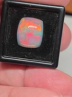 Top view of Ethiopian jelly opal in display box showing colour play