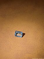 Emerald-cut aquamarine resting on surface