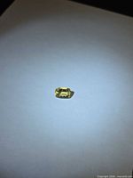 Golden Helidor gemstone under spotlight on white background, full view